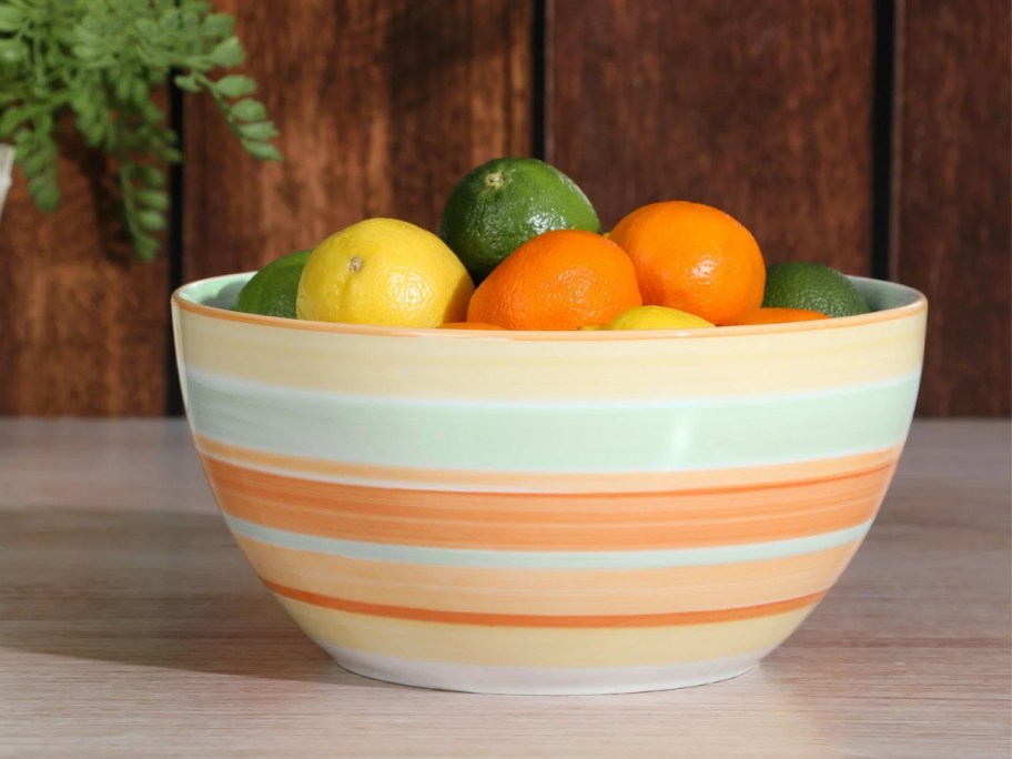 orange, white and blue striped serving bowl filled with citrus fruit