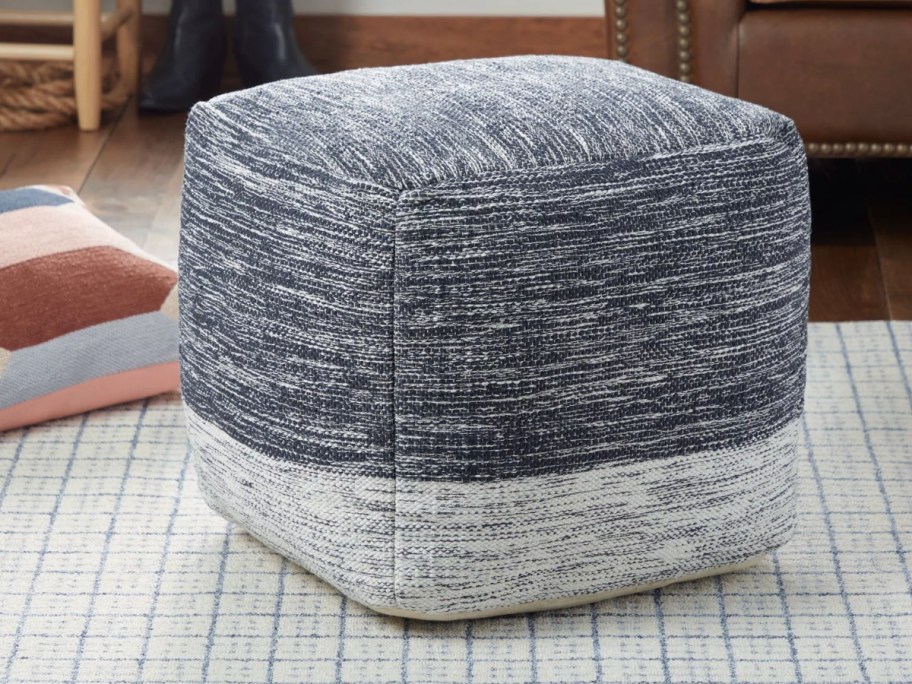 blue grey and white striped pouf on a living room floor