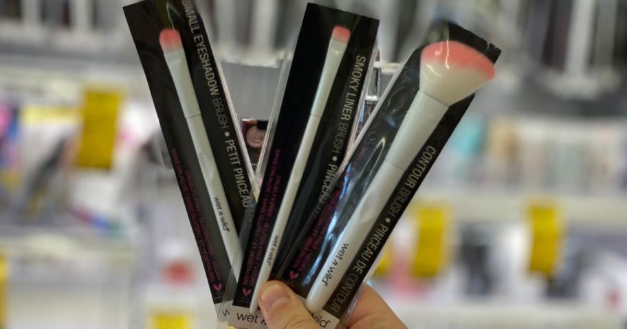 wet n wild cosmetic brushes being held by hand in store