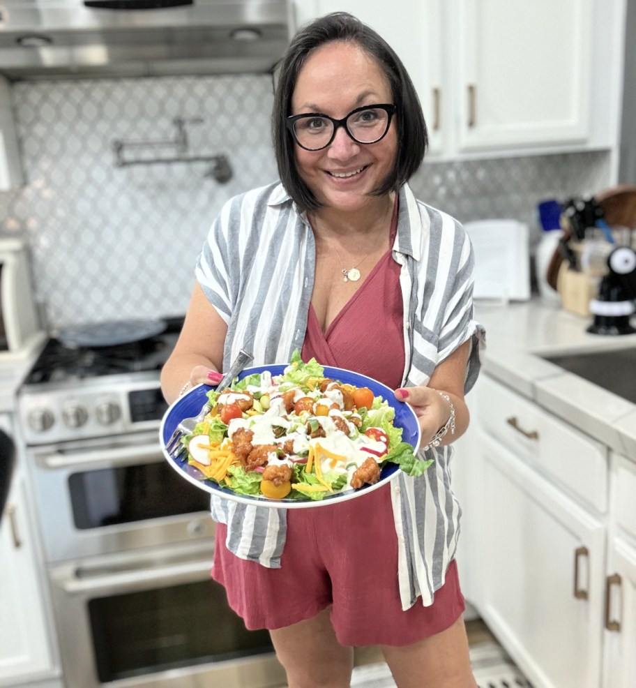 woman holding a sticky chicken finger salad