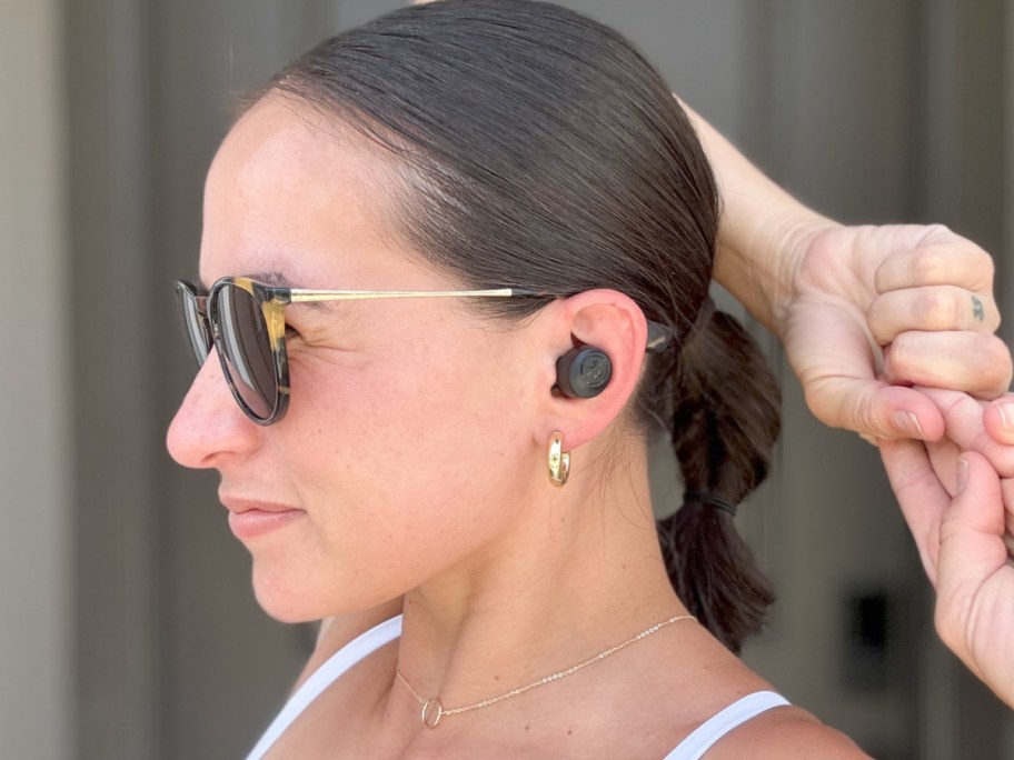 woman wearing black ear buds