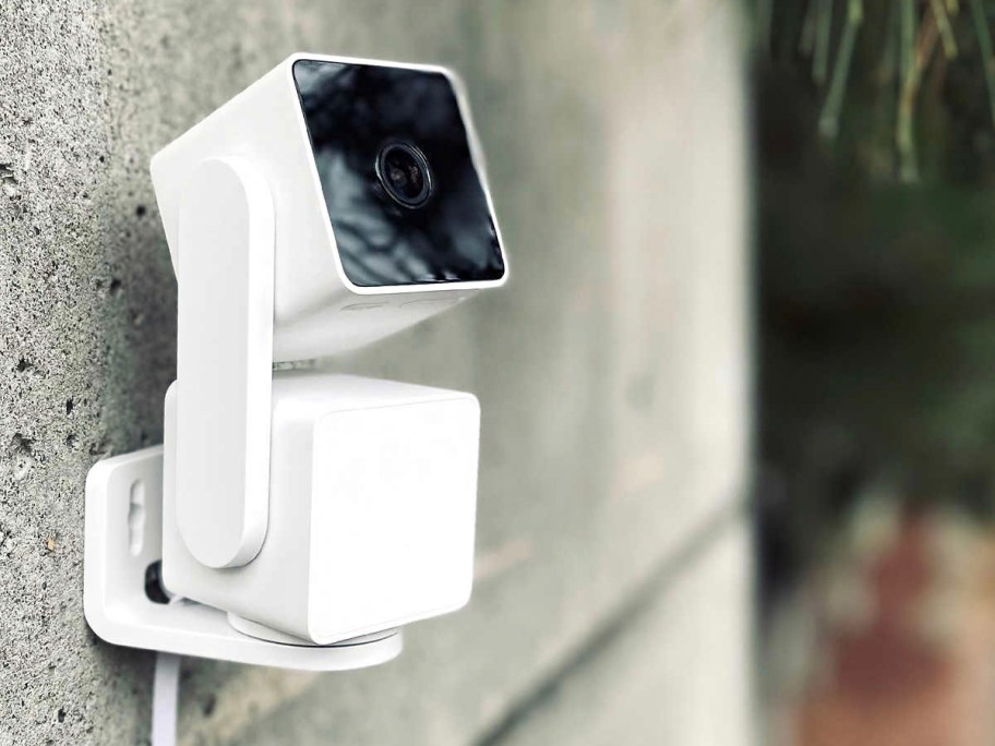 white security camera hanging on wall 