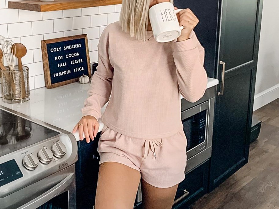 woman wearing beige loungeset drinking coffee in kitchen