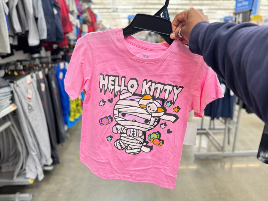 hand holding a kid's pink Hello Kitty as a Mummy Halloween Graphic Tee