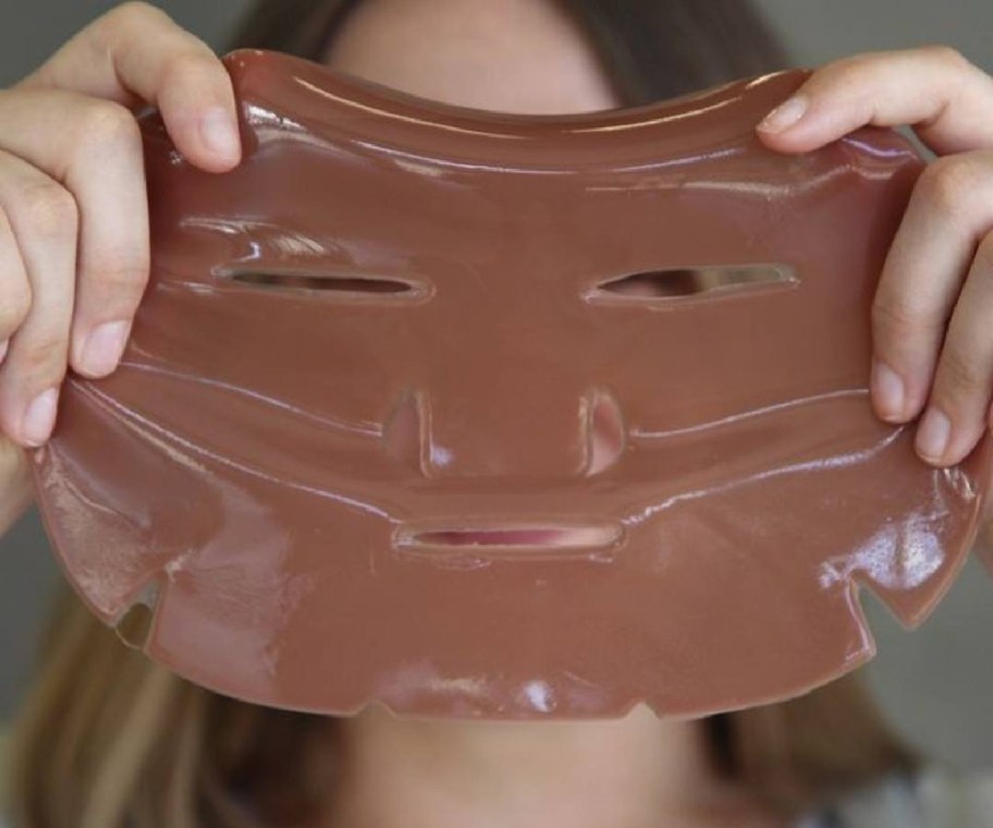 woman holding up caffeine face mask