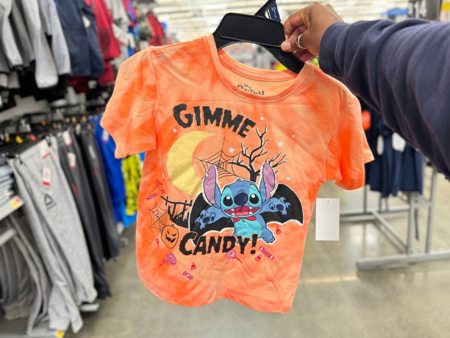 hand holding a kid's Halloween orange tie dye tee with Stitch on it