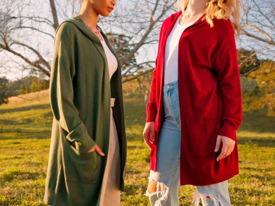 women wearing long cardigans with pockets and hoods, 1 in olive green, 1 in red