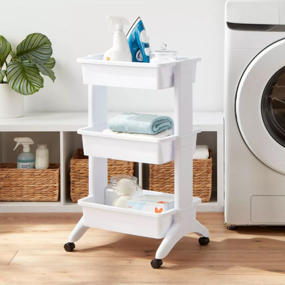 a white 3 tier rolling cart next to a washing machine