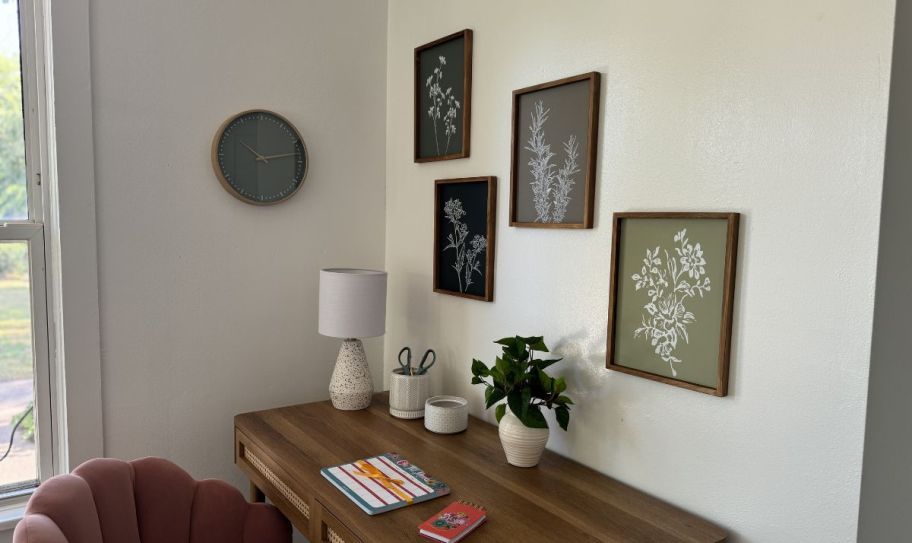 a 4-piece framed botanical art set hanging on a wall above a desk