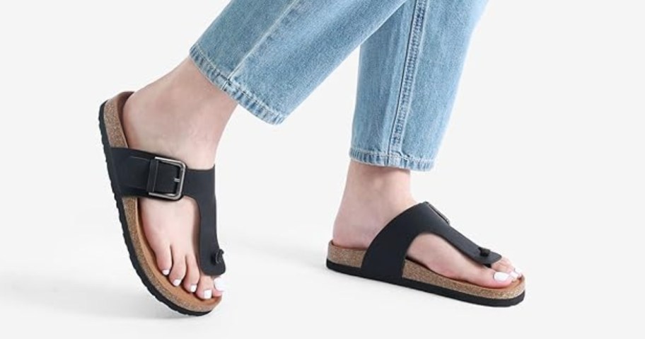 woman's feet wearing black footbed flip flop sandals