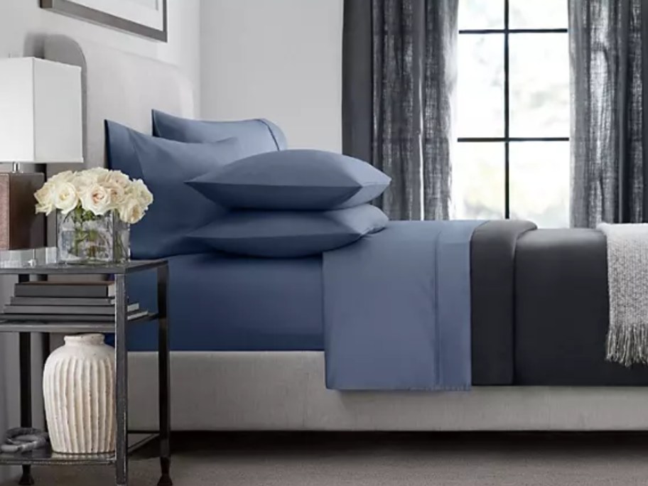 a bed with blue sheets and pillows with blue pillowcases on it