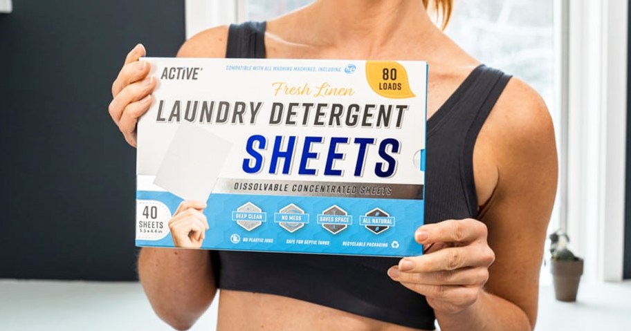 woman holding up a box of Active Laundry Detergent Sheets