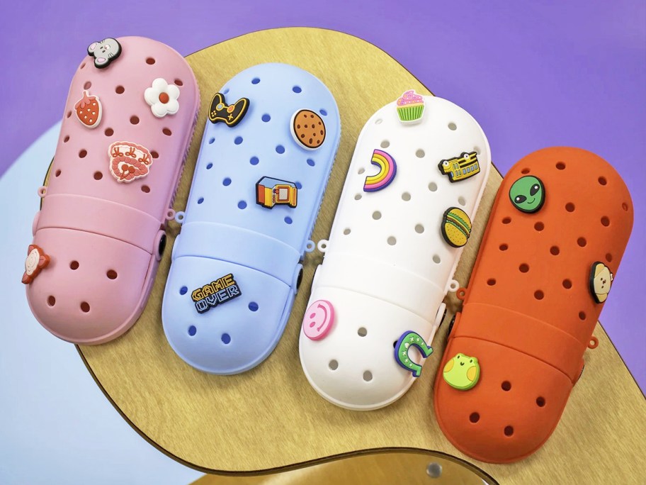 pink, blue, white, and red pencil cases covered in charms