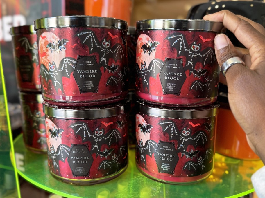 hand touching stack of red halloween candles