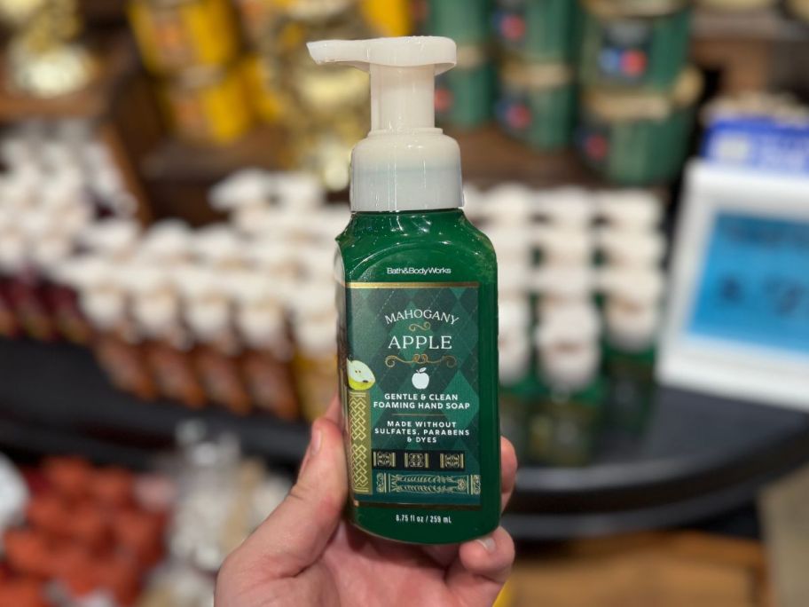 A person holding a Bath & Body Works hand soap container