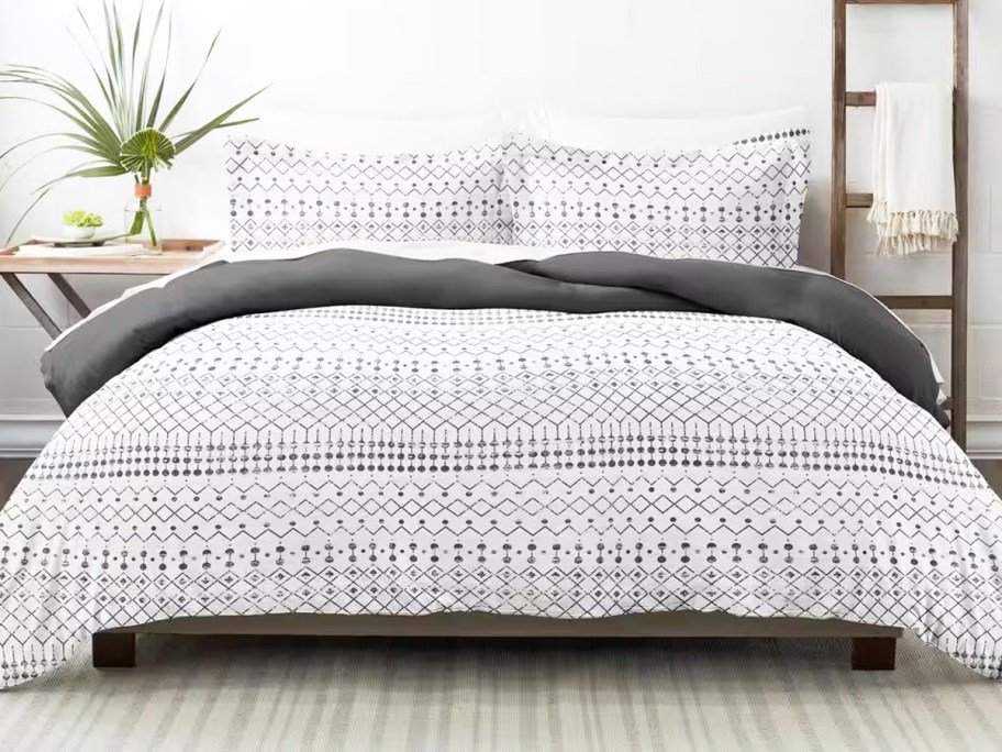 white and grey geometric print comforter and shams set on a bed
