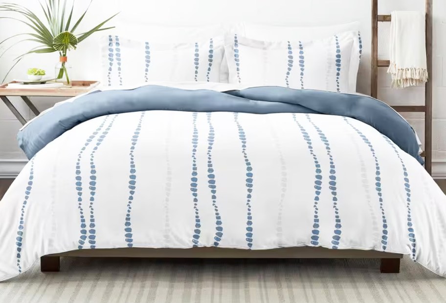 white and blue dotted print comforter and shams set on a bed