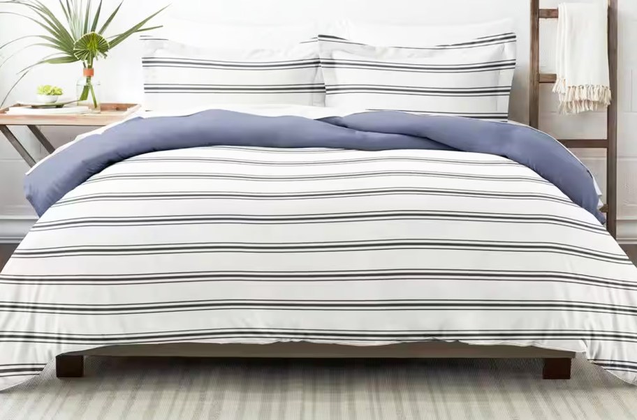 white and blue striped comforter and shams set on a bed