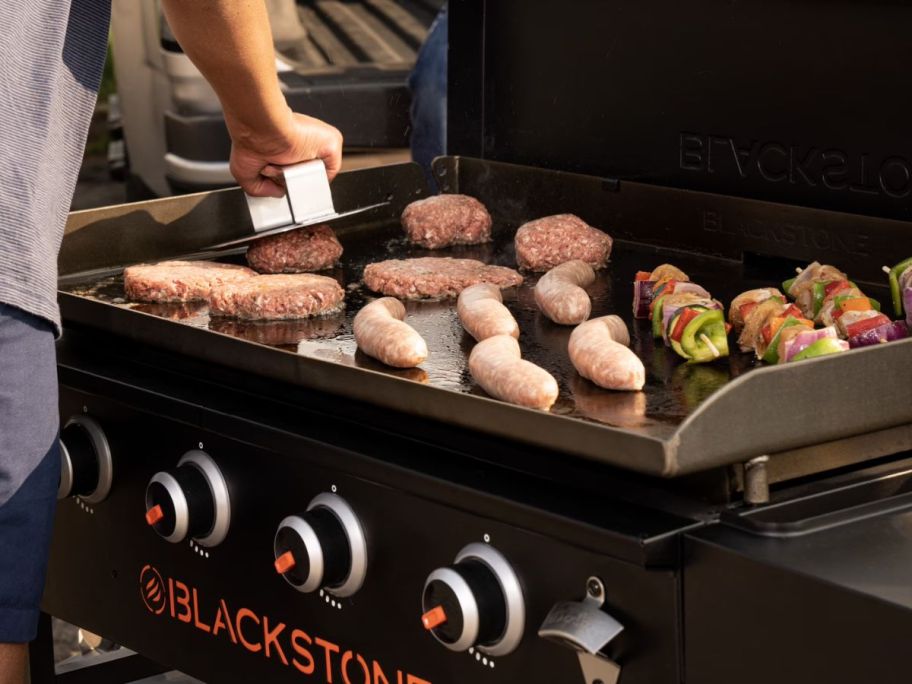 person cooking on Blackstone Original Outdoor 4-Burner 36" Flat Top Griddle Grill