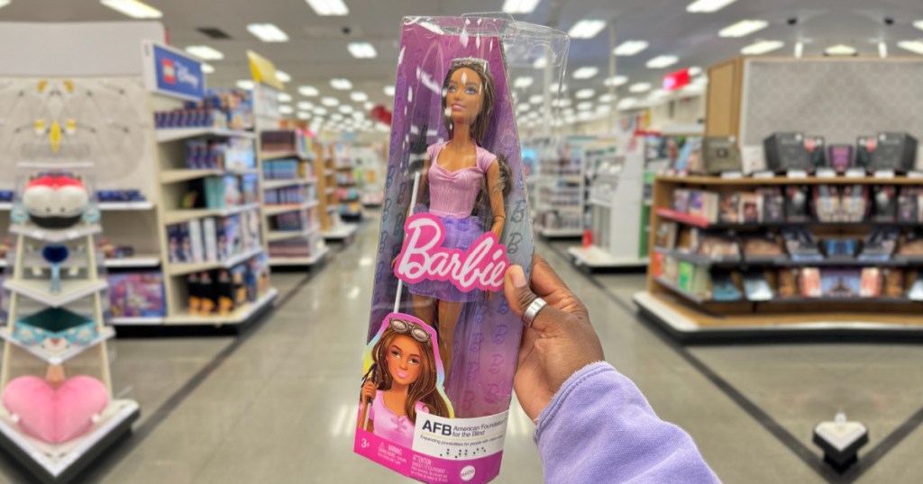 person holding blind barbie in target store