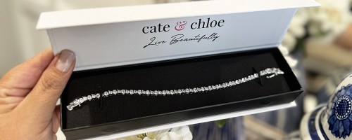 hand holding a silver tennis bracelet in box