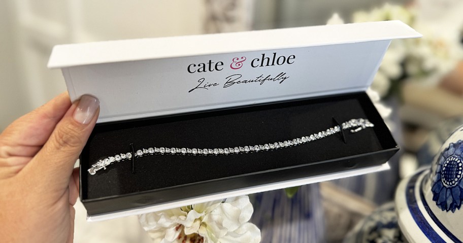 hand holding a silver tennis bracelet in box