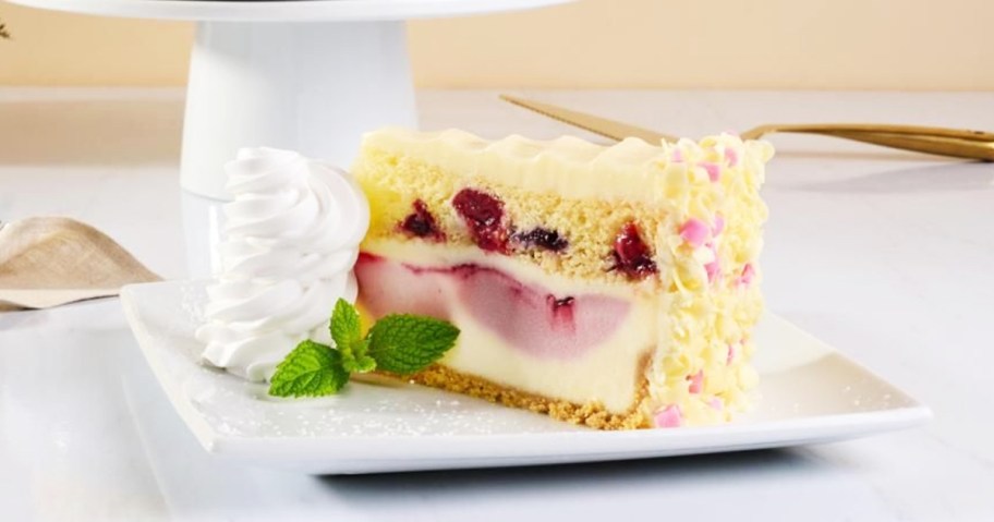 slice of triple berry cheesecake on white plate