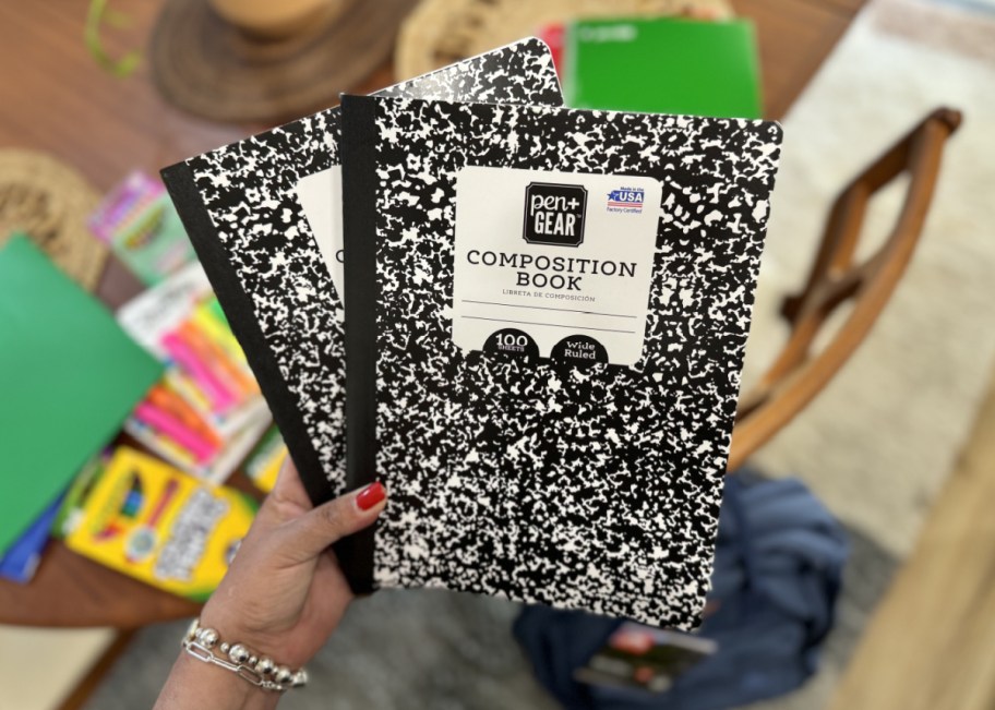 Hand holding two composition notebooks delivered via Walmart+