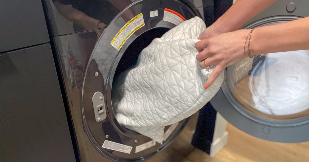 person removing coop pillow from washing machine