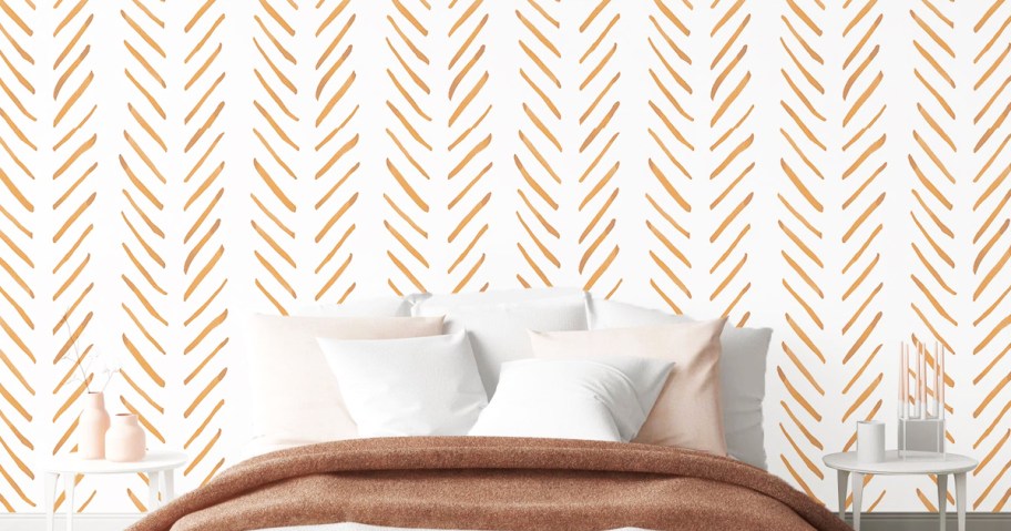 white and gold wallpaper on wall behind bed