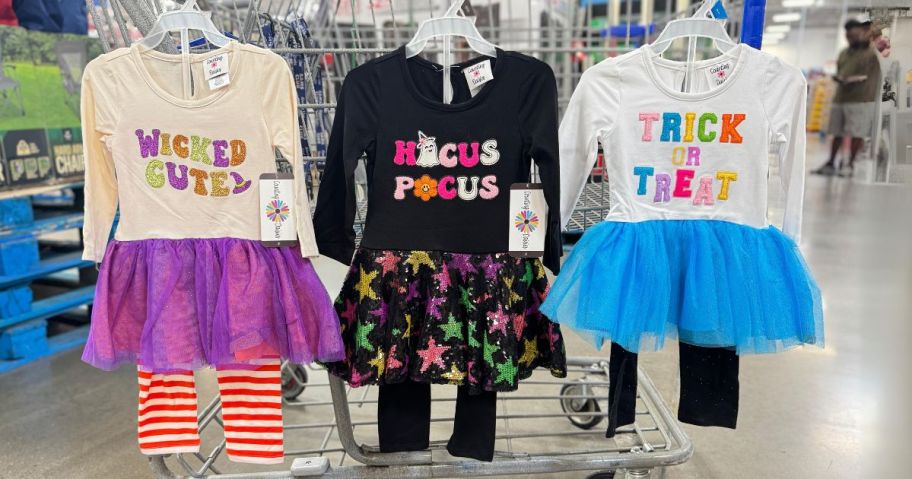 three Counting Daisies Halloween Tutu Sets hanging on cart in store