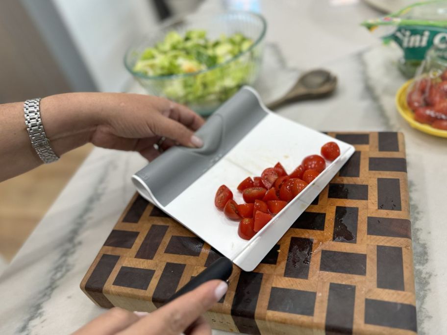 woman using knife to transfer food onto Dandy Folding Cutting Board Scraper
