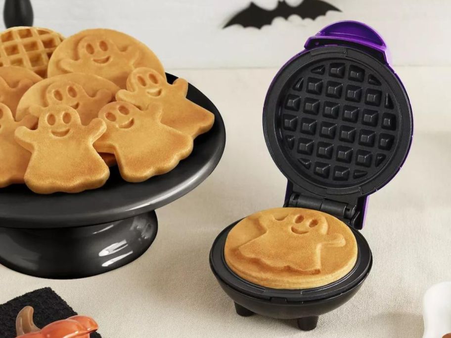 Dash Ghost Mini Waffle Maker on counter with a platter of ghost waffles next to it