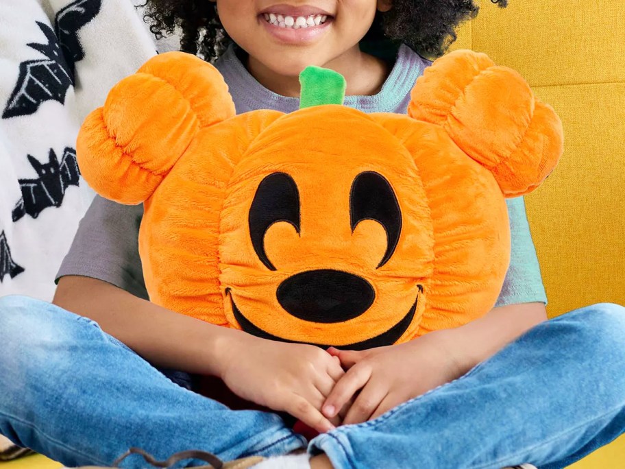 pumpkin mickey mouse plush in child's lap