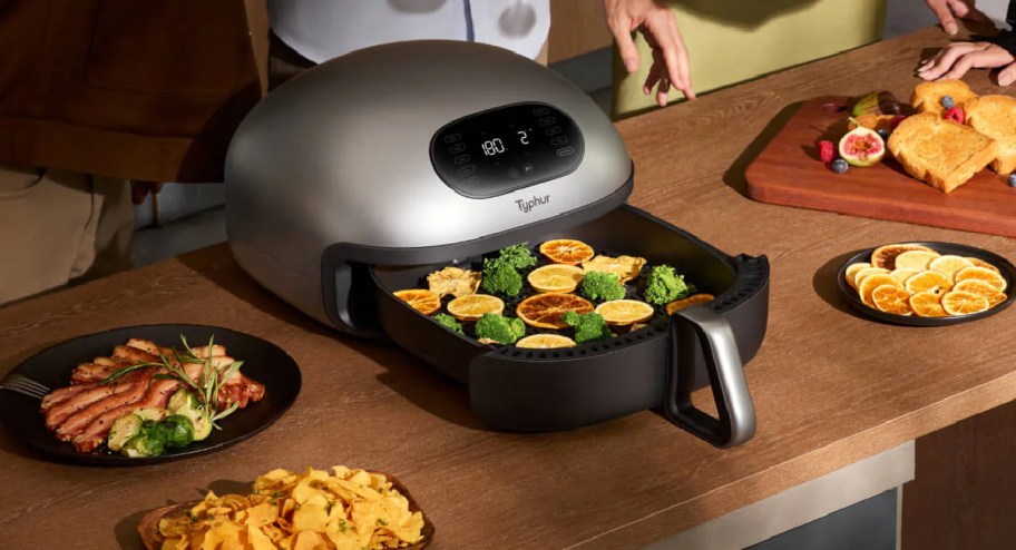 Dome air fryer with food inside and around it