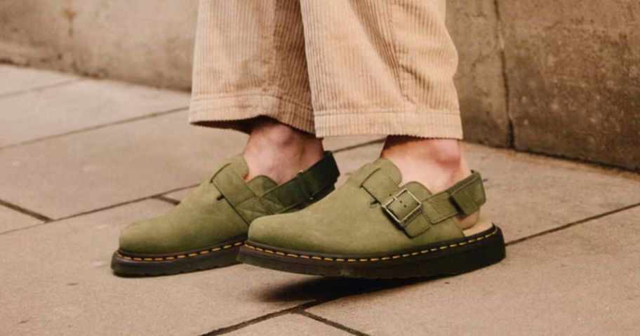 A woman wearing Dr. Martens mules in green 