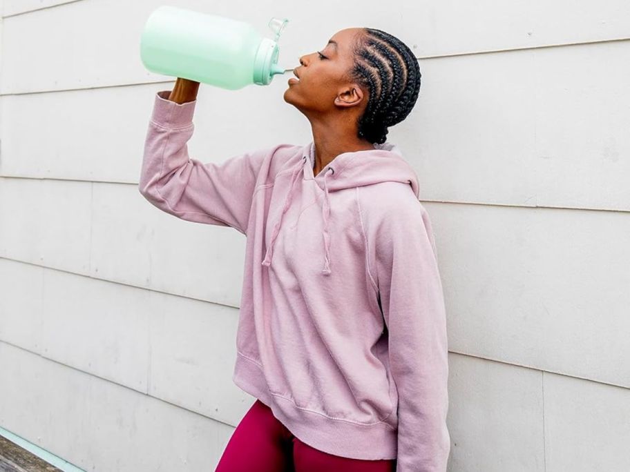 woman drinking from an Ello 1-gallon Hydration water bottle