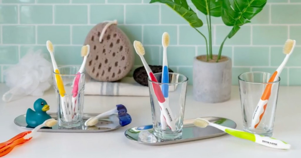 different colors of Flossing Toothbrushes on bathroom counter