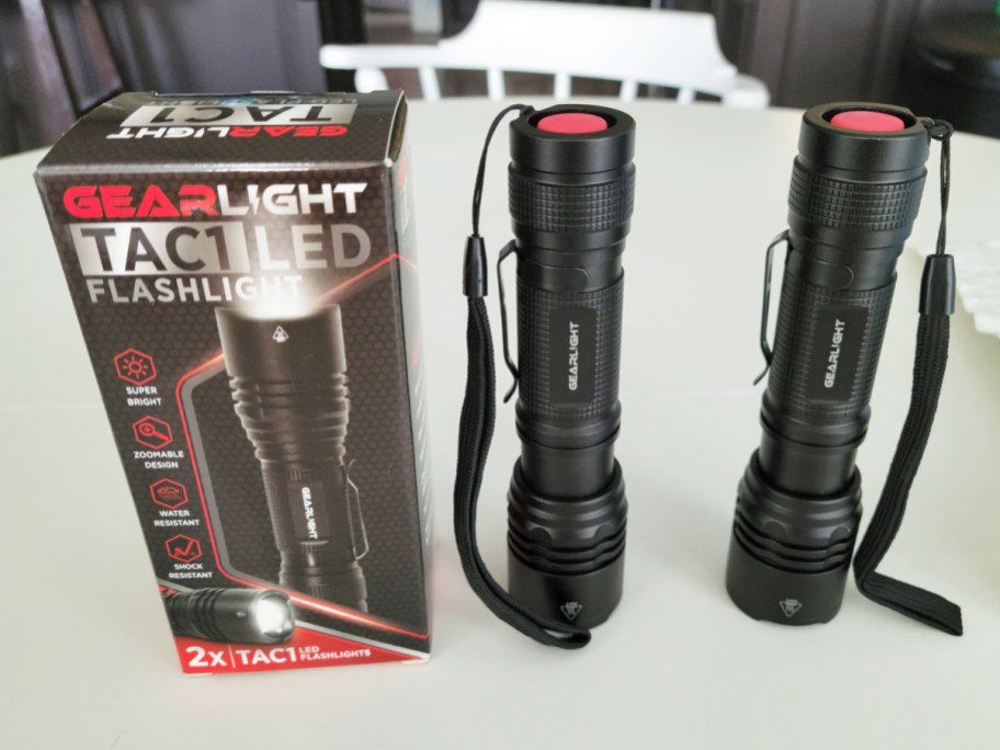 two flashlights and their box on counter