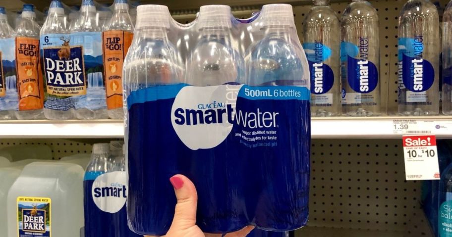 hand holding up a 6-pack of smartwater