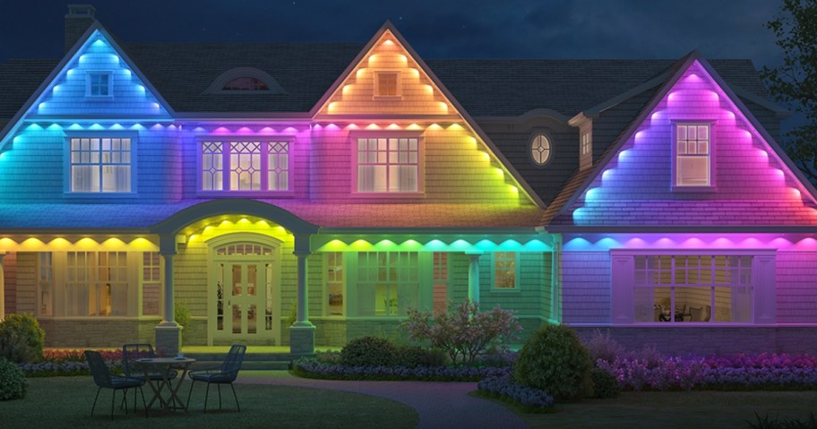 large house with front porch and eaves lit up in various colors with permanent outdoor lights