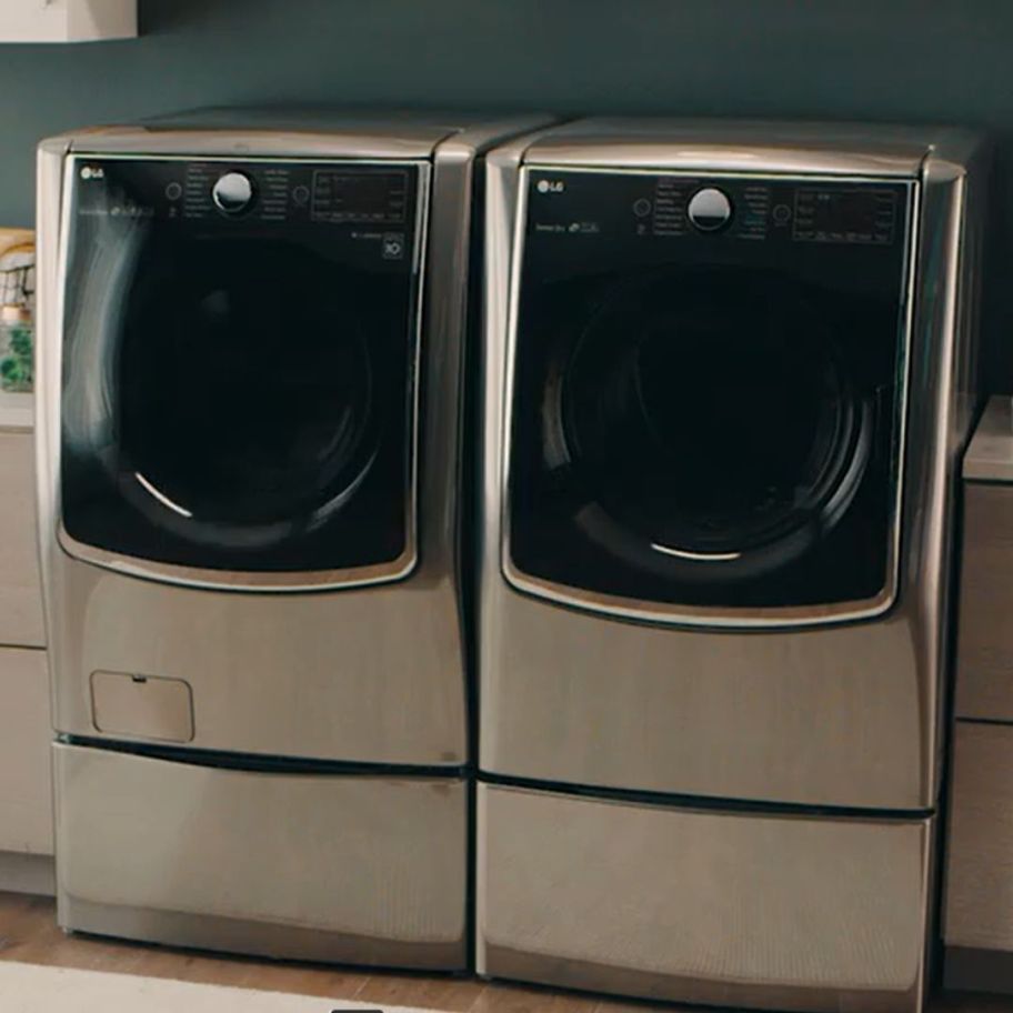 a stainless steel large washer and drying in a laundry room