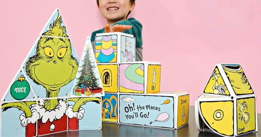 little boy behind a set of Magna-Tiles featuring How the Grinch Stole Christmas images