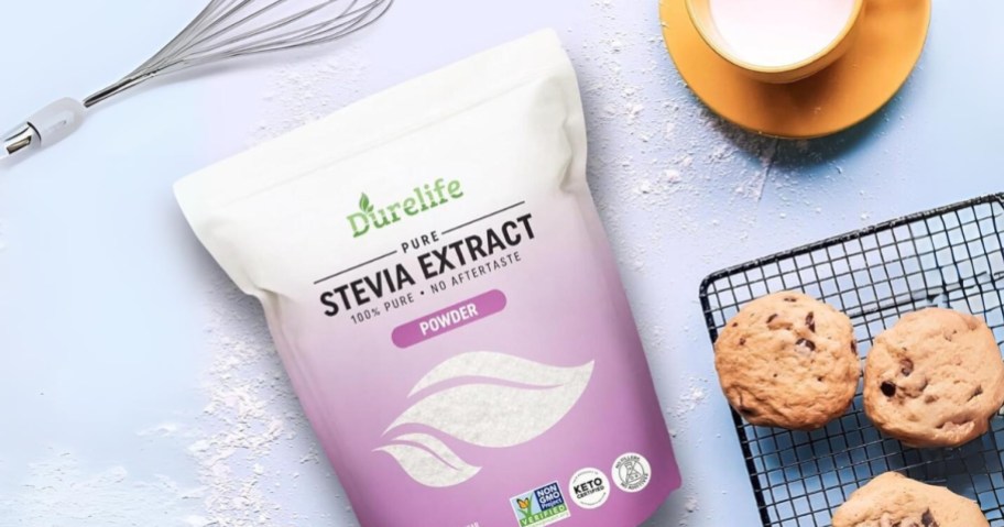 bag of Durelife 100% Pure Stevia Extract on a counter next to cookies on a cooling rack, cup of coffee, whisk