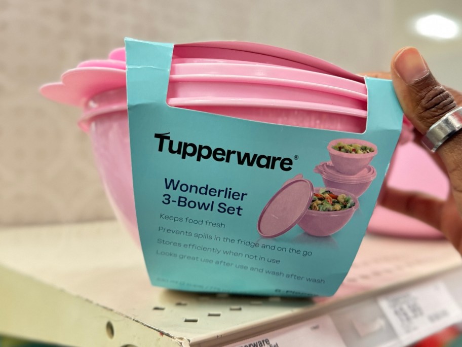 hand reaching for a set of 3 pink Wonderlier Bowls on a store shelf