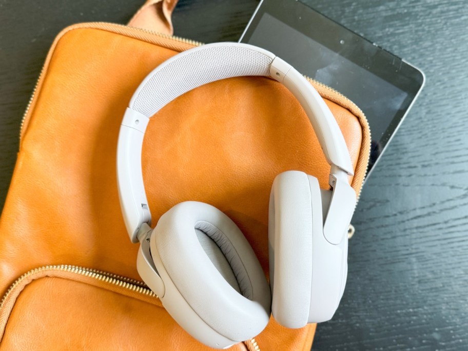 pair of headphones on a brown leather backpack bag