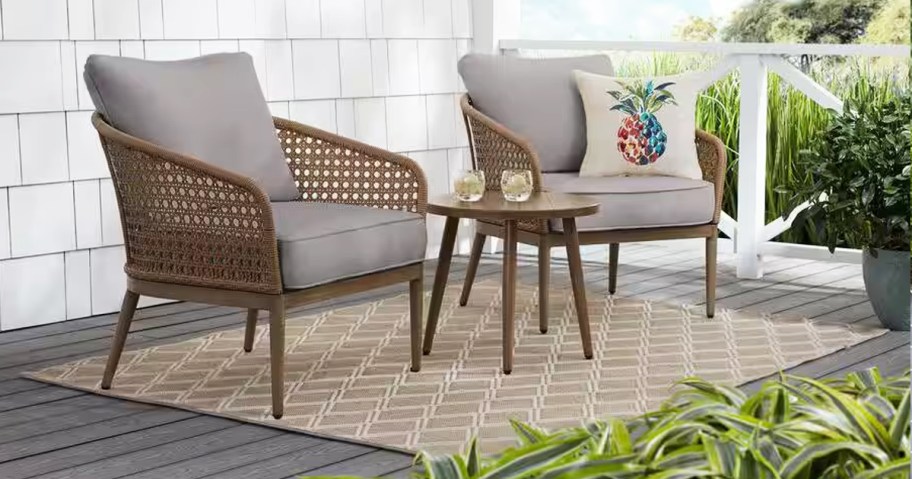 brown wicker patio chairs with grey cushions and side table