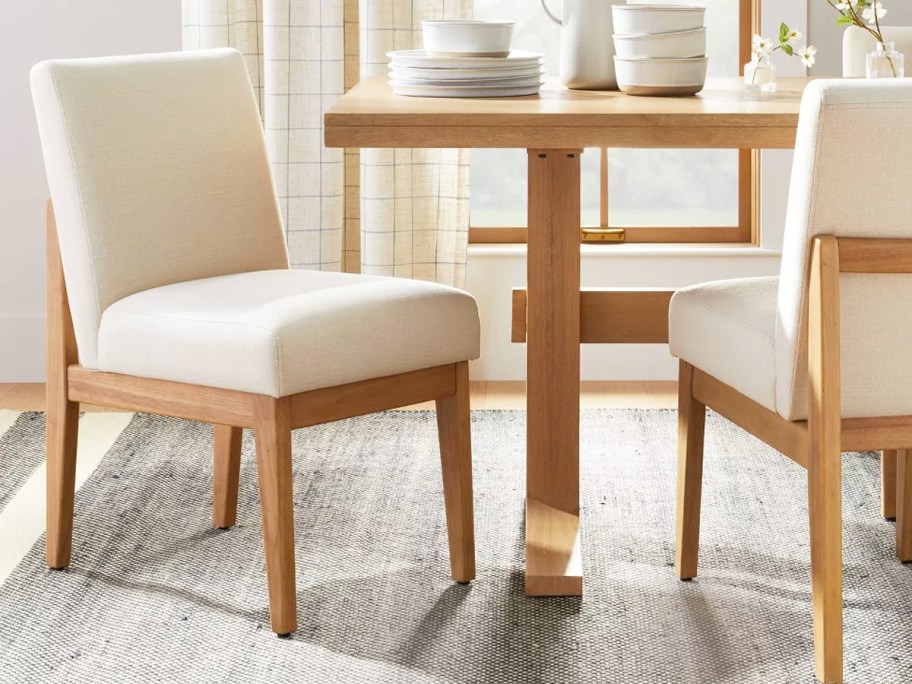 wood dining chairs with white cushions at kitchen table