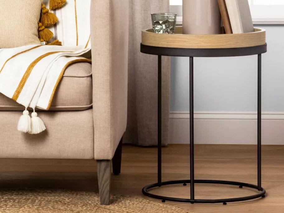 wood and black metal round side table next to sofa