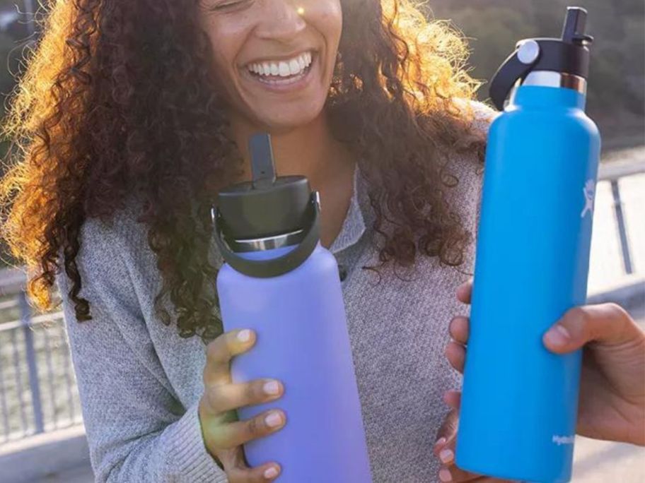 woman holding hydro flask tumblers outside